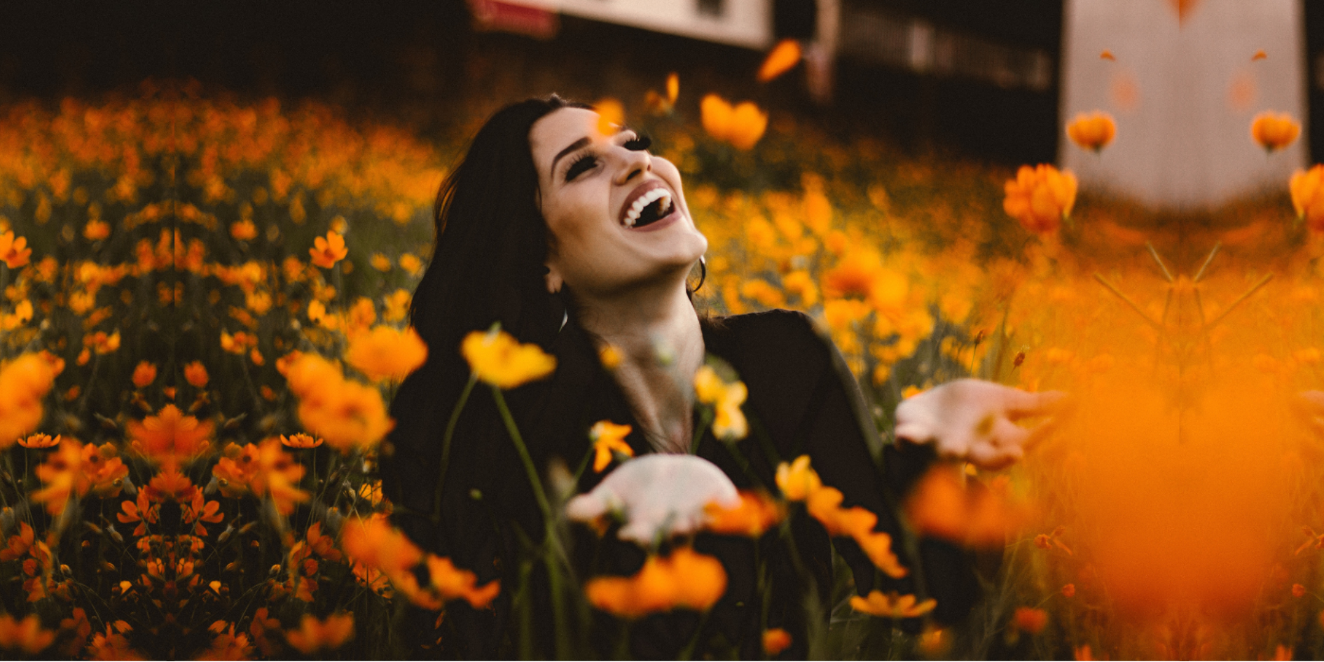 Woman happy sitting in a field of wild flowers